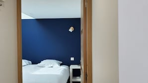 Un dormitorio con cama, mesita de noche y un velador.