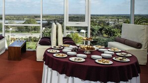 A dining area with a table set for a meal, overlooking a scenic landscape.