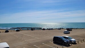 Ein Parkplatz mit Autos und Blick auf das Meer.