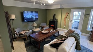 Una sala de estar con chimenea, televisor, sofá y una mesa de centro.