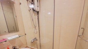 Casa de banho com lavatório, espelho e chuveiro.
