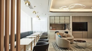 A modern interior with a dining area, seating, and a kitchen area. - Wuhan Bilang Jia Hotel (Optics Valley Financial Gangbei Subway Station) (Wuhan)