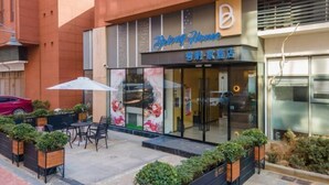 A hotel exterior with a modern design, outdoor seating area, and a clear entrance. - Wuhan Bilang Jia Hotel (Optics Valley Financial Gangbei Subway Station) (Wuhan)