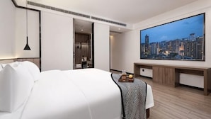 A modern hotel room with a large bed, a flat-screen TV, a desk, and a cityscape view. - Wuhan Bilang Jia Hotel (Optics Valley Financial Gangbei Subway Station) (Wuhan)