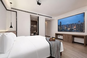 A modern hotel room with a large bed, a flat-screen TV, a desk, and a cityscape view. - Wuhan Bilang Jia Hotel (Optics Valley Financial Gangbei Subway Station) (Wuhan)