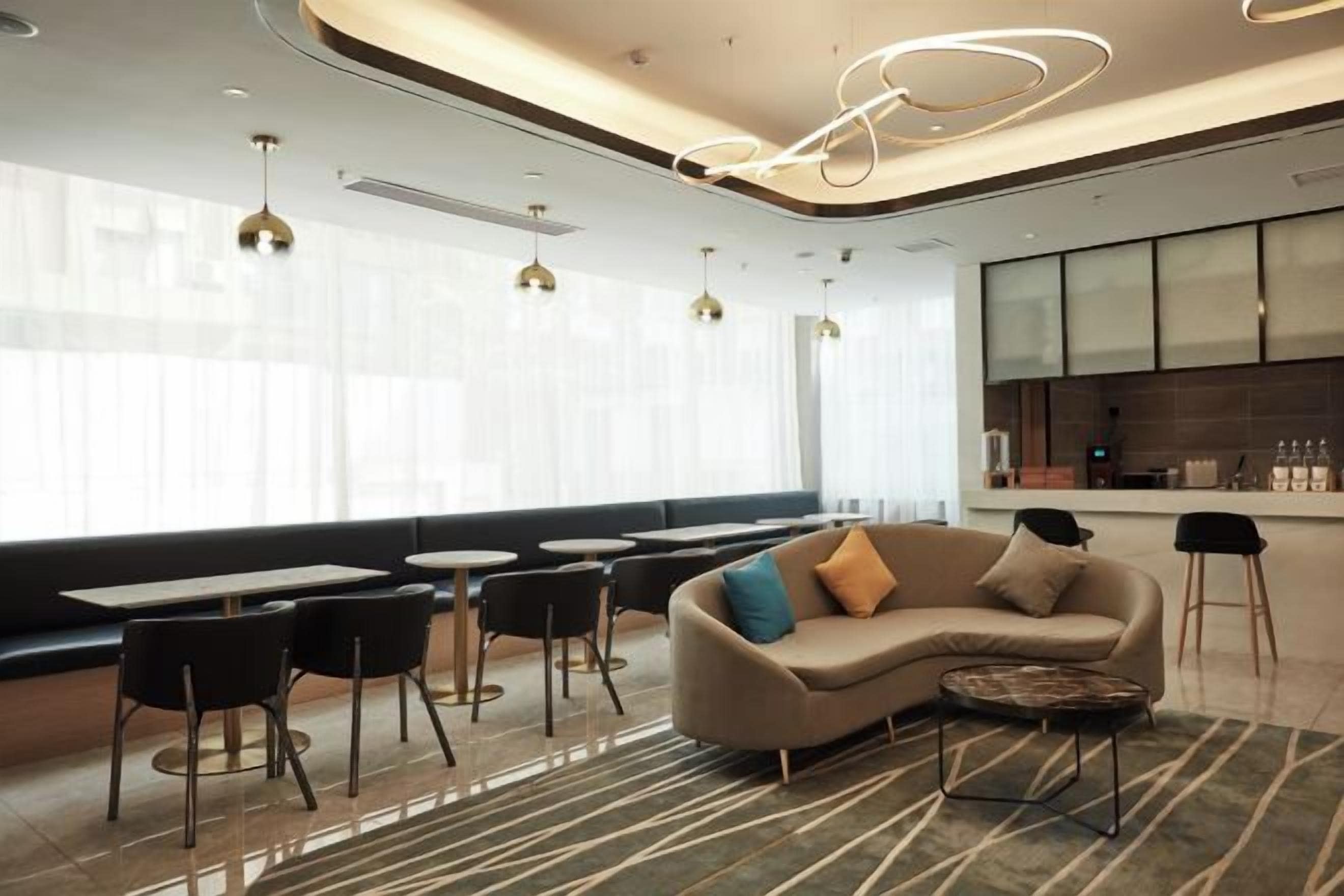 Ein stilvoller Lounge-Bereich mit Sitzgelegenheiten, einer Couch und einer Bar.