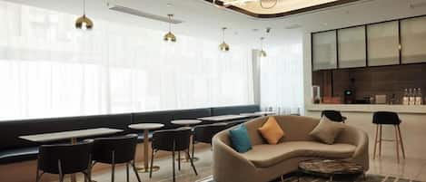 A modern lounge area with seating, a sofa, and a bar area.