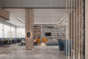 A modern hotel lobby with a central column, seating areas, a reception desk, and a TV screen. - Wuhan Bilang Jia Hotel (Optics Valley Financial Gangbei Subway Station) (Wuhan)