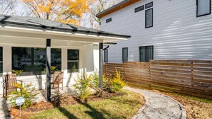 A modern house with a covered patio, a wooden fence, and a well-maintained lawn. - Quaint & cozy living minutes from downtown Raleigh (Raleigh)