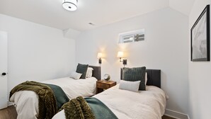 A bedroom with two beds, each with a headboard, bedside lamps, and a window. - Quaint & cozy living minutes from downtown Raleigh (Raleigh)