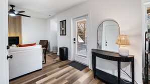 A modern living room with a sofa, a coffee table, a TV, and a ceiling fan. - Quaint & cozy living minutes from downtown Raleigh (Raleigh)