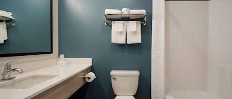 Un baño con lavamanos blanco, espejo, inodoro y cortina de ducha.