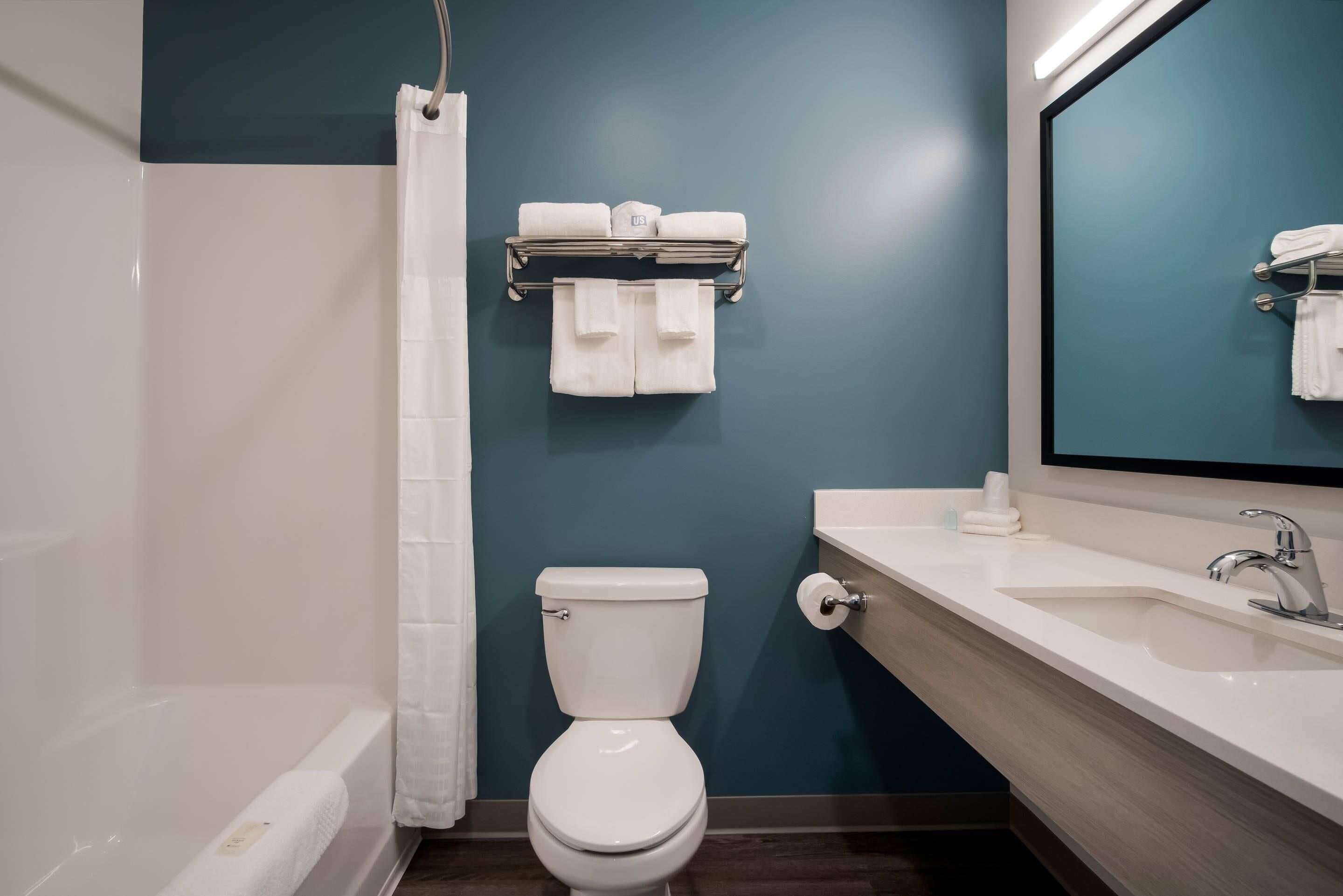 Une salle de bain équipée d’une baignoire, de toilettes, d’un lavabo et d’un porte-serviettes.