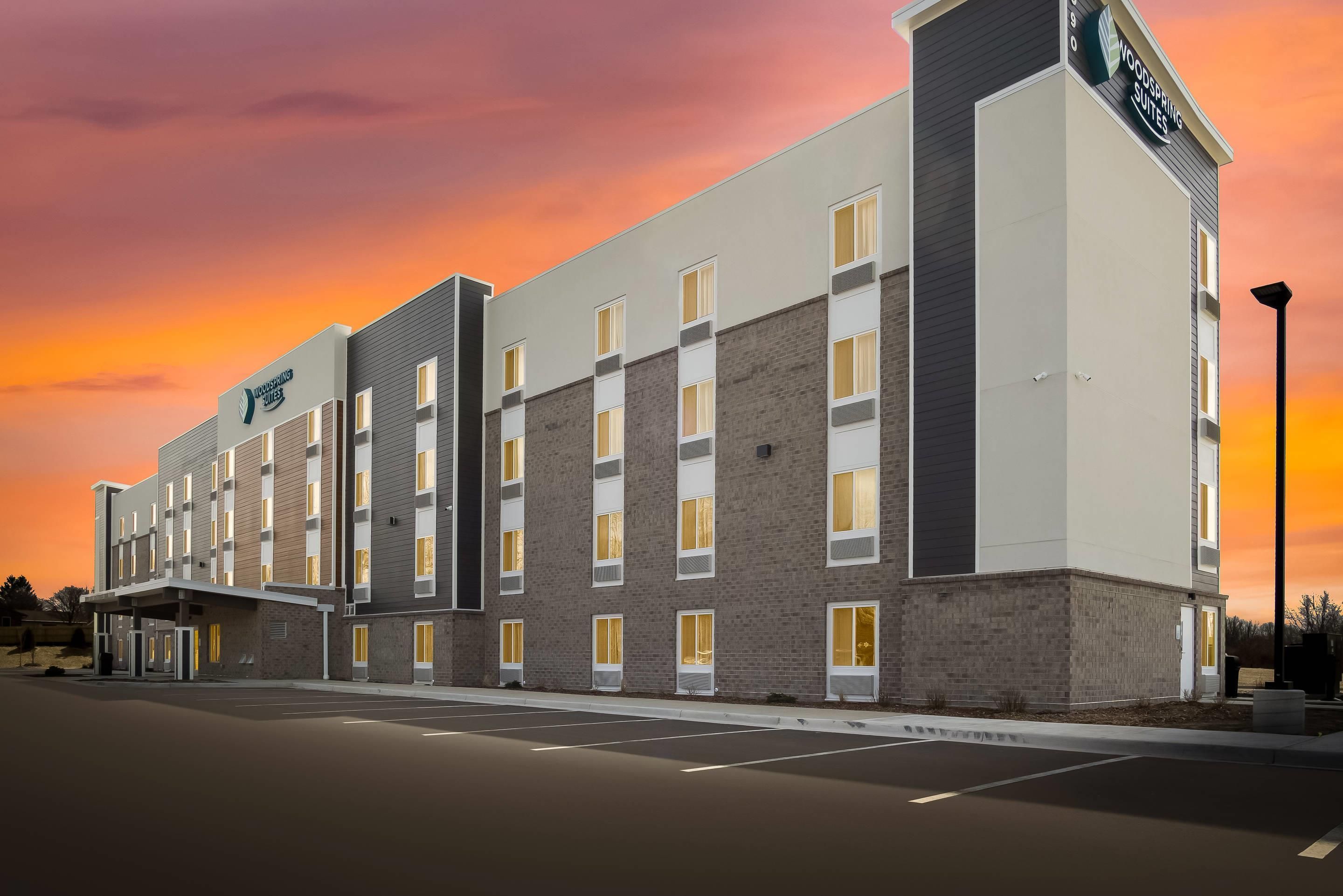 Moderni hotellirakennus, jossa on tasakatto, useita ikkunoita ja kyltti, josta ilmenee, että kyseessä on WoodSpring Suites -hotelli.