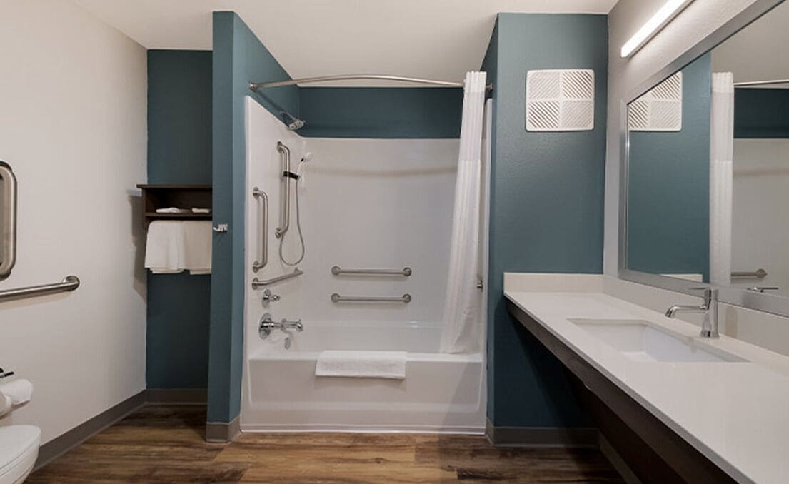 A modern bathroom with a shower, toilet, and sink.
