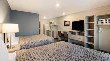 A hotel room with two beds, a desk, a TV, and a wardrobe.