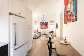 Relax in this stylish living space with a kitchen, seating area, and dining table.