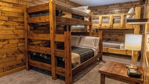 A bunk bed room with a wooden floor and a lamp on a table. - Phelps Lakeview Lodge Holiday House (Phelps)