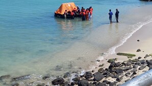 Een strandzicht met een groep mensen in de buurt van een kleine oranje tent.