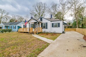 A single-story house with a front porch, a flag, and a fenced yard. - Modern Home, Great Deck & Yard- Peaceful at Potter (Mobile)