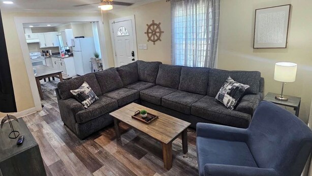 Una sala de estar con un sofá modular, una mesa de centro y un mueble para televisión.