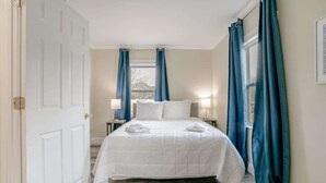 Une chambre d’hôtel avec un lit, une fenêtre et des rideaux.