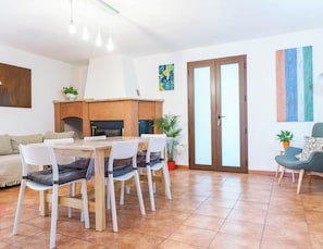 Ein modernes Wohnzimmer mit Essbereich, Kamin und großem Fenster.