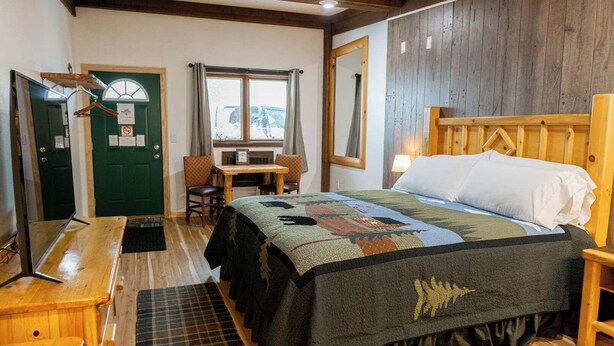 Een gezellige kamer met een bed, een bureau en een stoel.