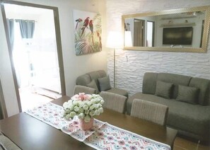 Deluxe Condo | Living area | 55-inch Smart TV with cable channels, TV