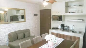 Deluxe Condo | Living area | 55-inch Smart TV with cable channels, TV