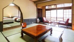 Ein traditioneller japanischer Raum mit Tatami-Böden, einem niedrigen Holztisch und Blick durch große Fenster nach draußen.