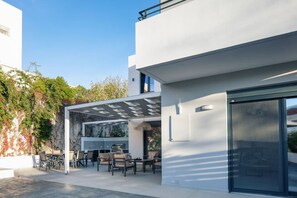 Une maison moderne dotée d’un patio, de mobilier d’extérieur et d’une pergola.