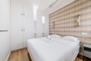 Ein Schlafzimmer mit einem Bett, einem Kleiderschrank und einer Wandleuchte.