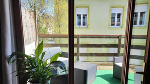 A balcony with wicker furniture and a potted plant. - Charming chalet-style accommodation, 12 minutes from the town center (Schiltigheim)