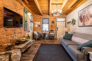 Cozy seating area with sofa, armchairs, and a television.