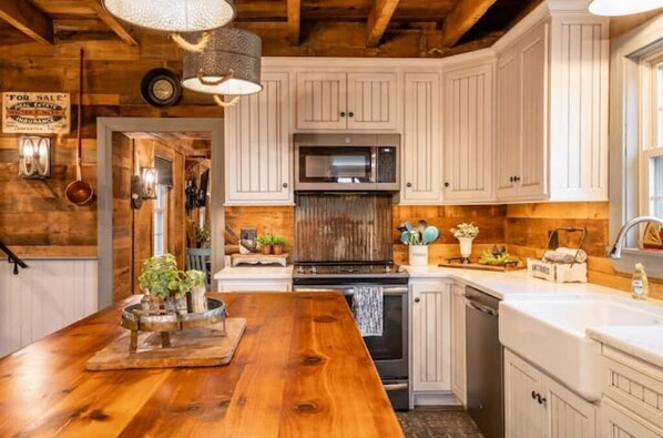 Kitchen with a central island, sink, and appliances.