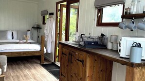 Un dormitorio con cama, mesita de noche y ventana.