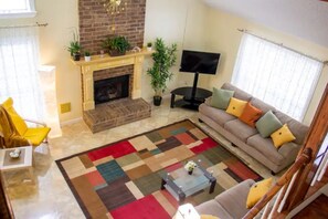 Una sala de estar con chimenea, sofá y mesa de centro.