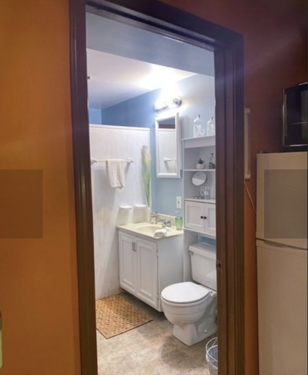A compact bathroom with a toilet, sink, and shower area.