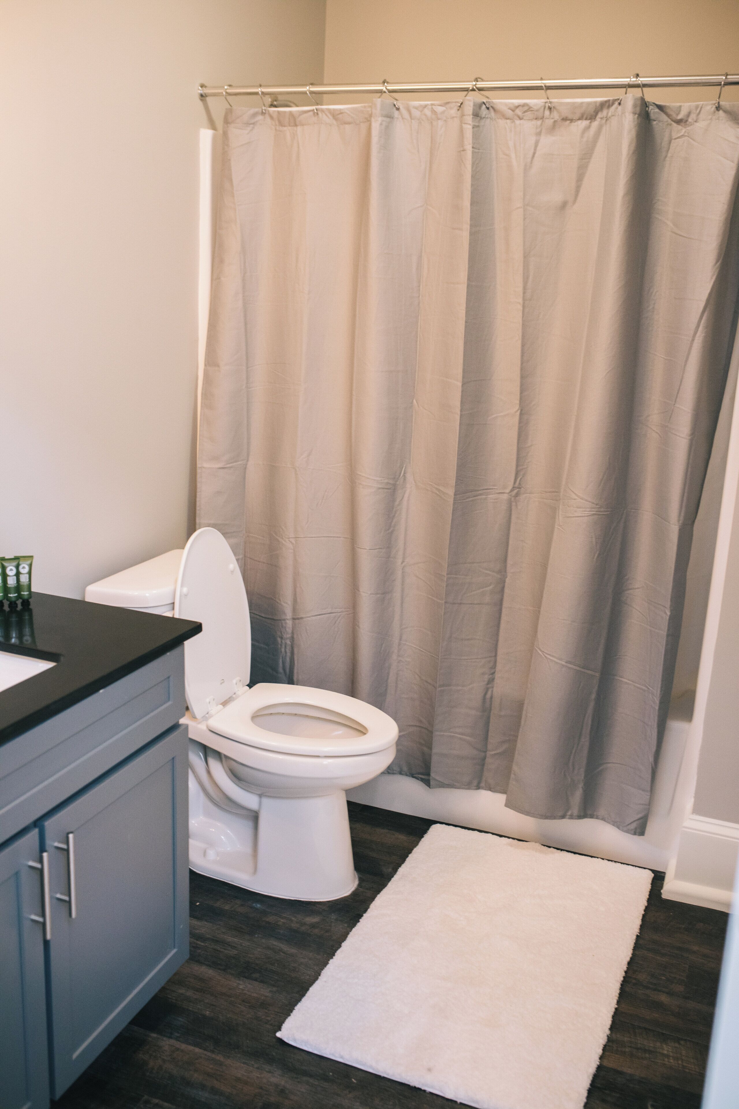 Un baño con inodoro, lavamanos y cortina de ducha.