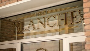 A storefront with a glass door and a brick wall. The sign above the door reads "The Blanche." - The Blanche  (Lake City)
