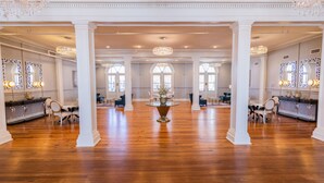 A spacious hotel lobby with high ceilings, chandeliers, and a central round table. - The Blanche  (Lake City)
