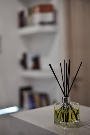 A small square bottle with black reed sticks on a white surface. - Modern Villa in Heraklion City Center, Crete (Heraklion)