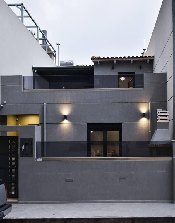 A modern multi-story building with a flat roof, large windows, and external lighting fixtures. - Modern Villa in Heraklion City Center, Crete (Heraklion)