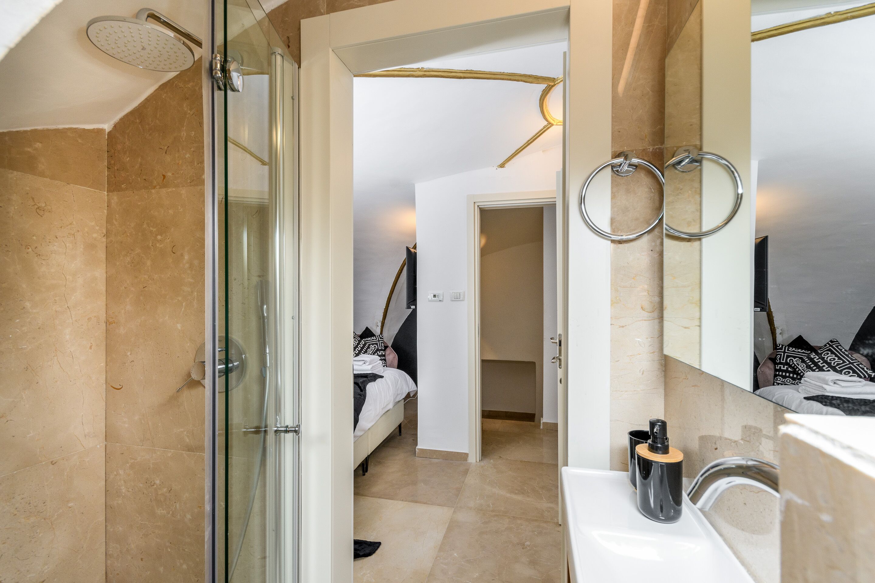 A modern bathroom with a glass shower enclosure, a white sink, and a large mirror.