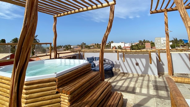 A wooden pergola structure with a pool and seating area on a rooftop terrace. - POUSADA SOLE - D3 EXPERIENCE (Cruz)