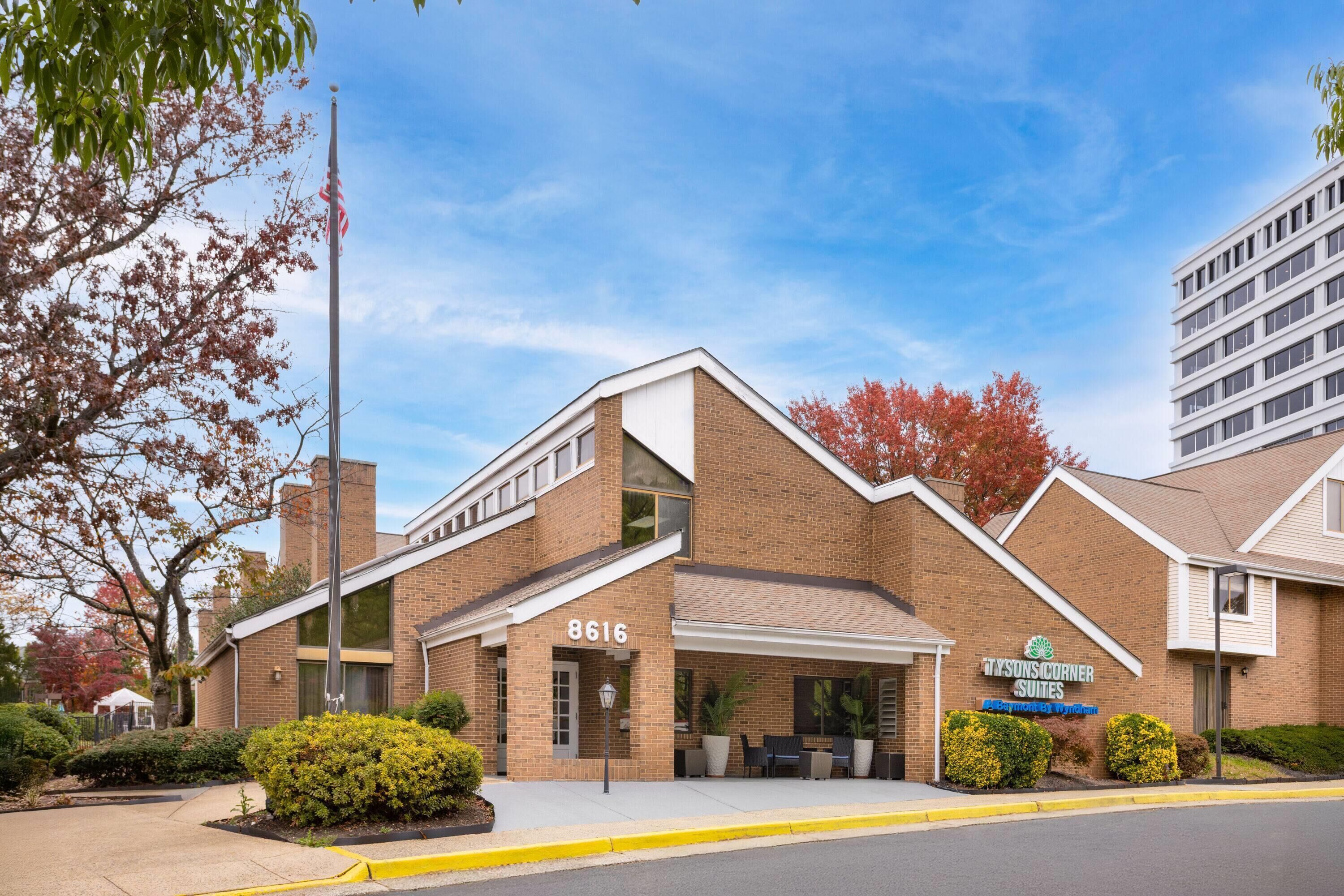 A brick building with a sign reading "Mysons Corner Suites" and the number 8616.