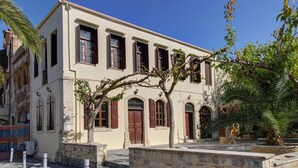 A building with multiple windows, a stone pathway, and a tree in the foreground. - Ruby Studio - Old Town Rethymno (Rethymno)