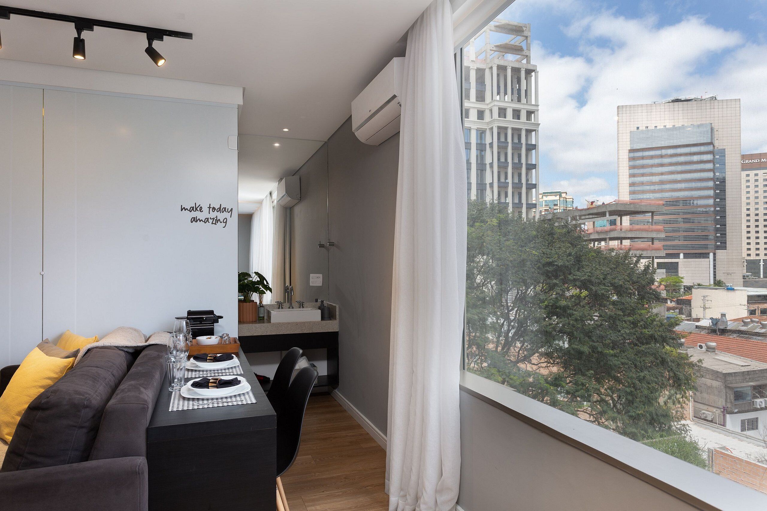 Un salon moderne avec un canapé, une table à manger et une vue sur le paysage urbain.