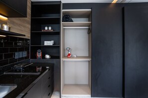 A modern kitchen with black cabinetry, a countertop, and a built-in oven.